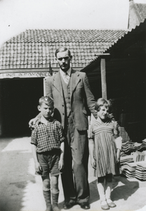 875845 Portret van Cees van Rooijen met zijn broertje Henk en zusje Nel, op een opslagplaats van de N.V. van de ...